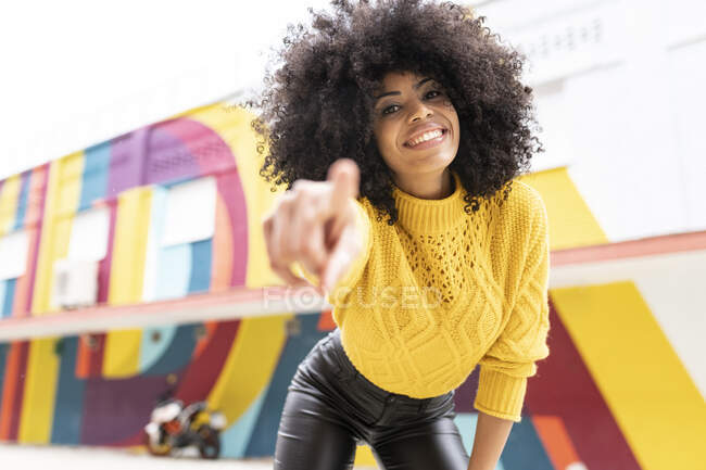 Femme souriante pointant du doigt tout en se tenant à l'extérieur — Photo de stock
