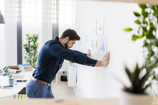 Erschöpfter männlicher Unternehmer lehnt im Büro an Wand — Stockfoto