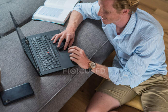 Libero professionista di sesso maschile che lavora su laptop in soggiorno — Foto stock