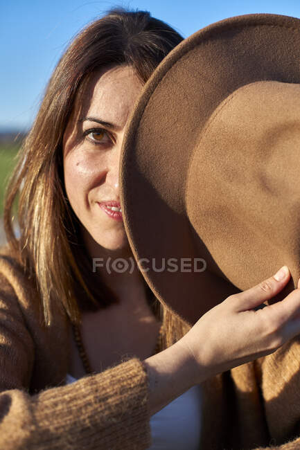 Жінка тримає капелюх перед лицем. — стокове фото