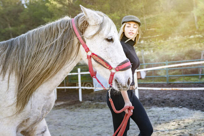 Femme avec cheval dans le paddock — Photo de stock