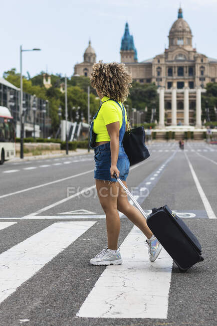 Route touristique féminine avec valise dans la rue de la ville — Photo de stock