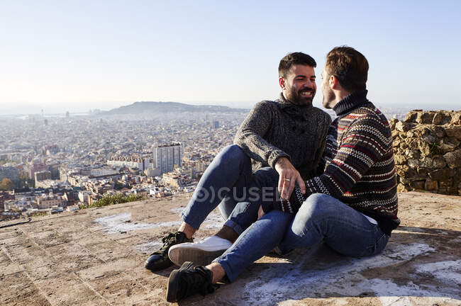 Felice coppia gay seduta sul punto di osservazione durante il fine settimana, Bunkers del Carmel, Barcellona, Spagna — Foto stock