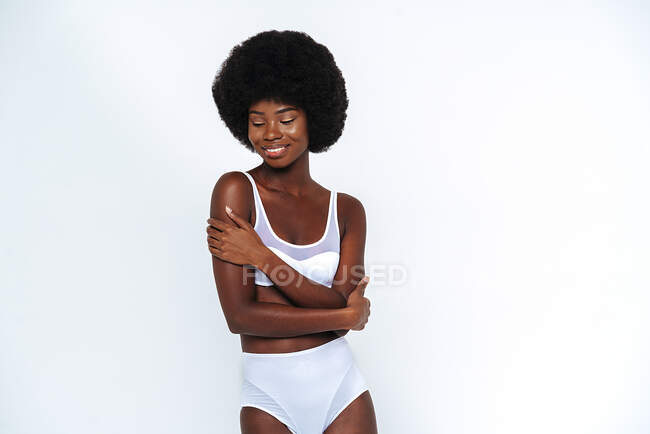 Afro-americano magro mulher vestindo lingerie com braços cruzados posando contra fundo branco — Fotografia de Stock