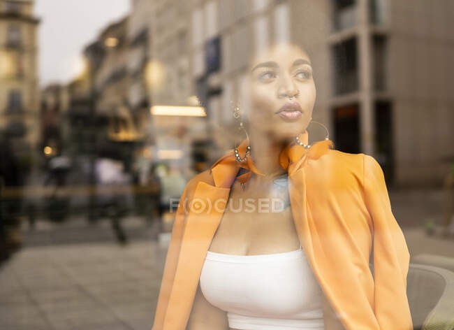 Nachdenkliche Frau blickt durch Glas auf Café — Stockfoto
