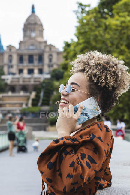 Дивна жінка сміється, розмовляючи на розумному телефоні в місті. — стокове фото