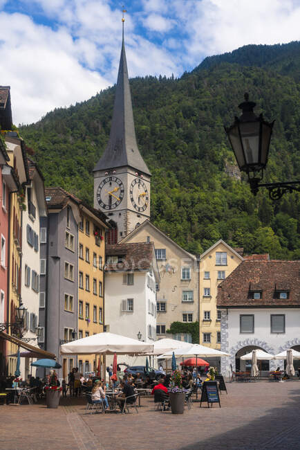 Plaza de Arcas con la aguja de la iglesia de San Martín en el fondo contra la montaña en Chur, Suiza - foto de stock