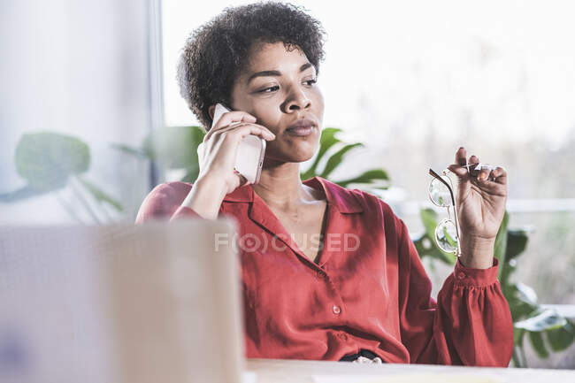 Frau telefoniert, sitzt zu Hause vor Laptop — Stockfoto