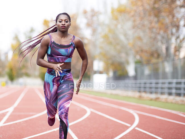Junge Sportlerin in Sportkleidung läuft auf der Strecke — Stockfoto