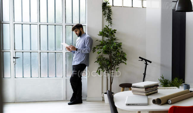 Joven hombre de negocios usando tableta digital en oficina creativa - foto de stock