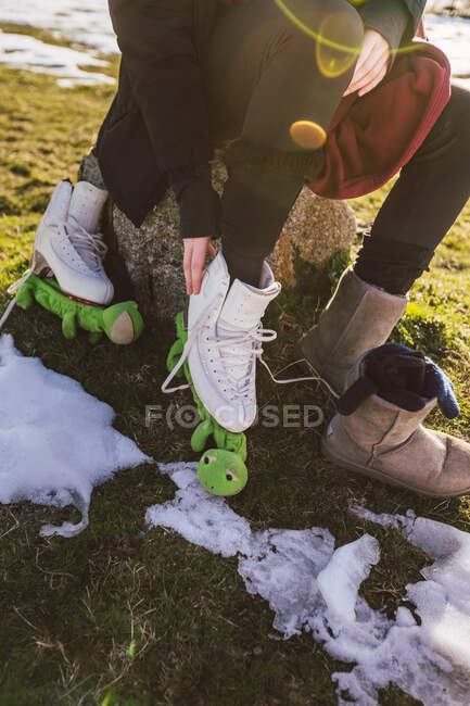 Low section of female ice-skater changing footwear — Stock Photo