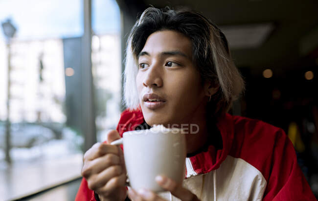 Giovane che prende un caffè nel caffè durante l'inverno — Foto stock