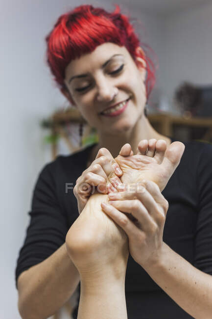 Женщина-хиропрактик массирует ногу молодой женщины — стоковое фото