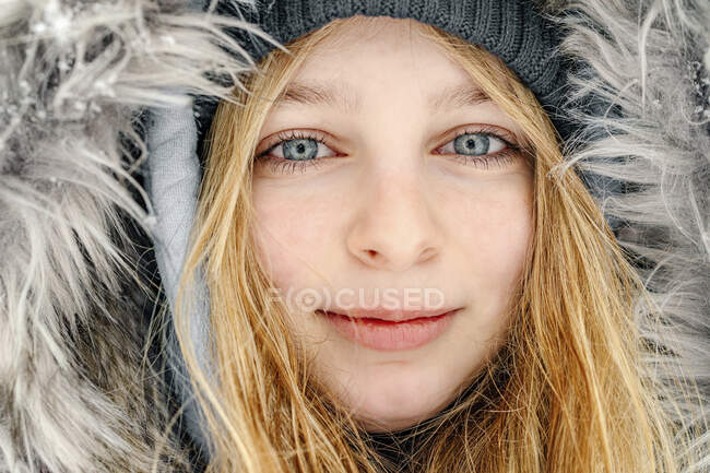 Primo piano della ragazza che indossa cappello di pelliccia fissando mentre sorride all'aperto — Foto stock