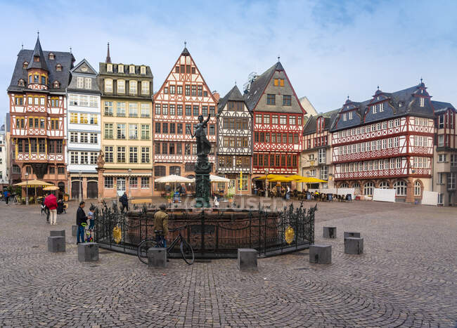 Alemania, Frankfurt, Roemerberg, Fuente de Justicia en la plaza del casco antiguo con casas de entramado de madera - foto de stock