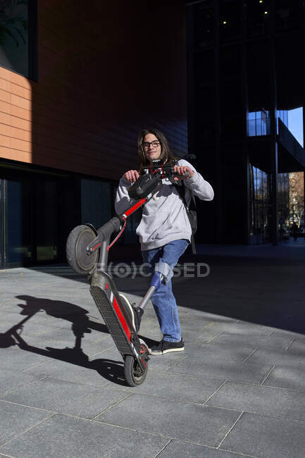 Jeune homme handicapé avec scooter électrique debout sur le sentier — Photo de stock