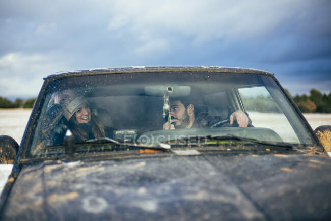 Homme parlant à la radio CB tout en voyageant avec une amie en voiture contre le ciel — Photo de stock