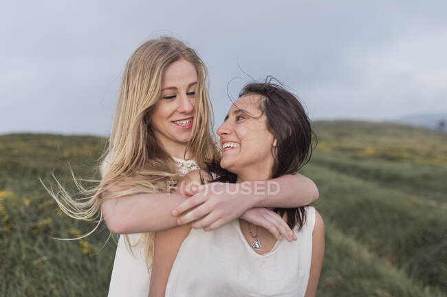 Sorridente femmina con braccio intorno di amico divertirsi — Foto stock