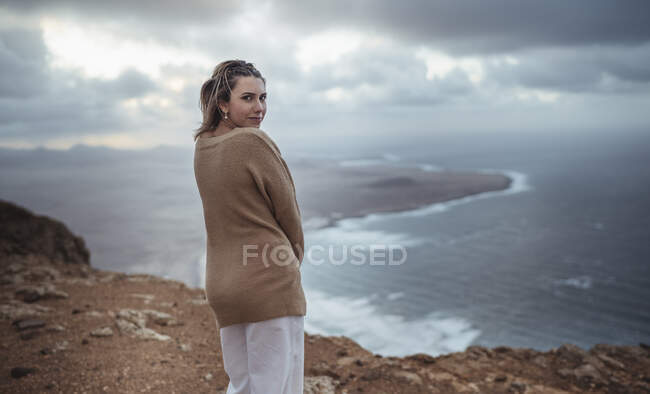 Donna che fissa in piedi sulla montagna contro Famara Beach, Lanzarote, Spagna — Foto stock