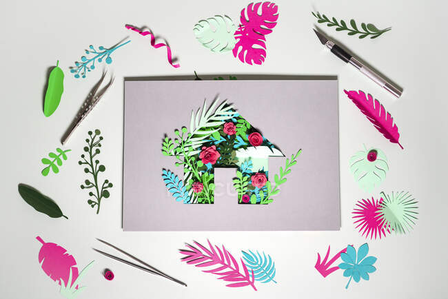 Paper Craft of Eco Home mit Pflanzen und Blumen inmitten von Fetzen auf weißem Hintergrund — Stockfoto