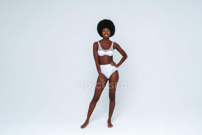 Afro-americano magro donna indossare lingerie in piedi su sfondo bianco — Foto stock