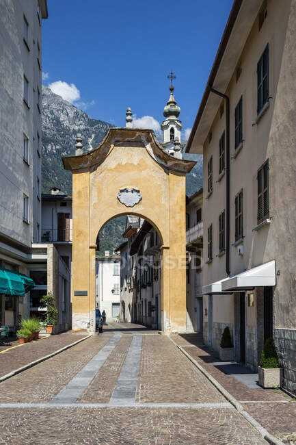 Chiesa di Santa Maria ad arco tra edifici in città nella giornata di sole, Valchiavenna, Chiavenna, Provincia di Sondrio, Lombardia, Italia — Foto stock