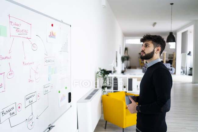 Бізнесмен дивиться на дошку в офісі — стокове фото