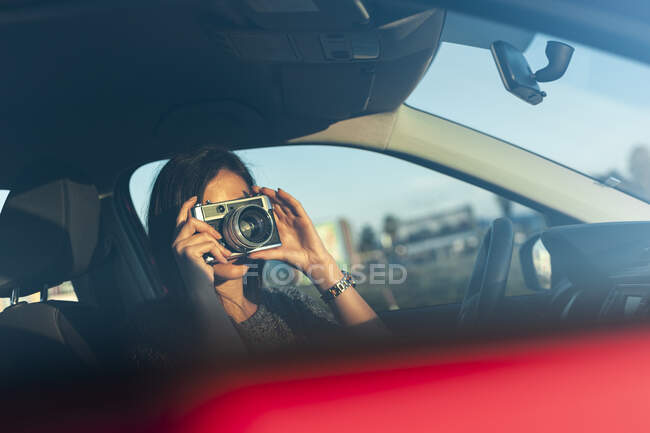 Jovem fotografar com câmera de filme de carro durante o fim de semana — Fotografia de Stock