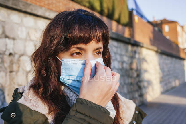 Young woman wearing protective face mask during COVID-19 — Stock Photo