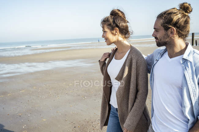 Petit ami regardant petite amie tout en marchant sur la plage pendant le week-end — Photo de stock