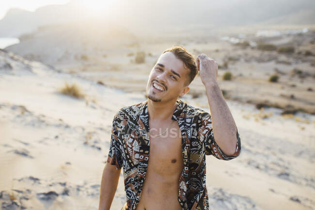 Feliz hombre guapo usando camisa desabotonada en el desierto en Almería, Tabernas, España - foto de stock