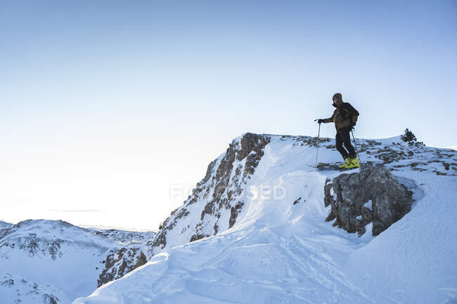 Male mountain climber on mountain summit against sky — Stock Photo