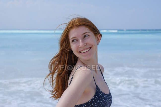 Smiling woman looking away while standing against sea — Stock Photo