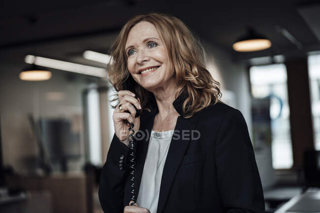 Hermosa mujer de negocios hablando por teléfono en la oficina - foto de stock
