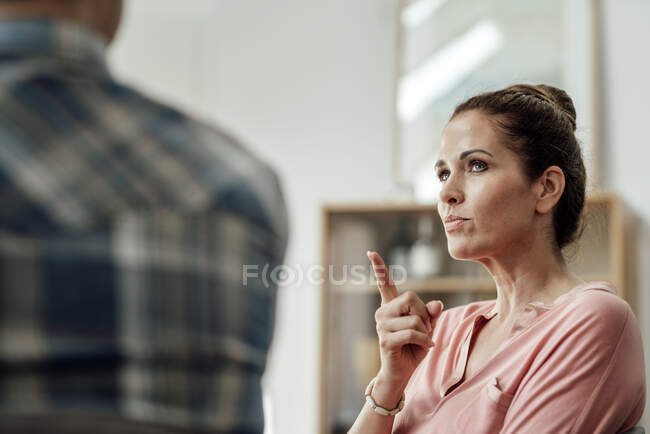 Donna matura gesticolare mentre parla con l'uomo in appartamento — Foto stock
