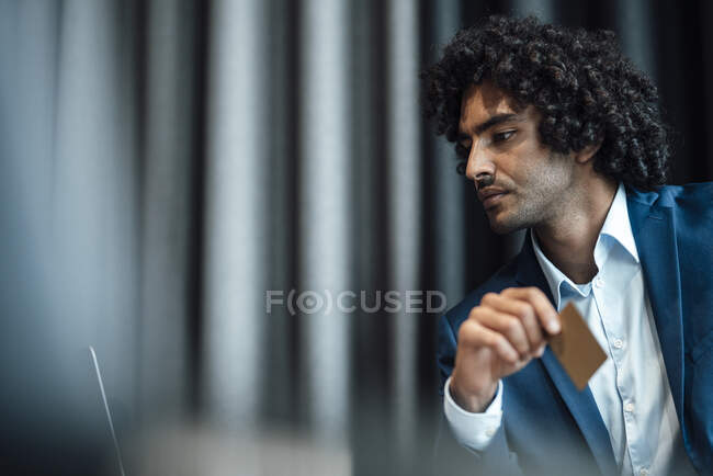 Confident male entrepreneur holding credit card at office — Stock Photo