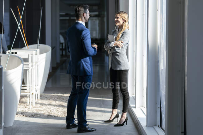 Lächelnde Geschäftsfrau spricht im Büro mit Kollegin — Stockfoto
