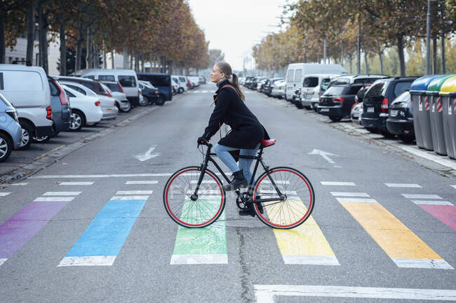Жінка їздить на багатокольоровому велосипеді зебру. — стокове фото