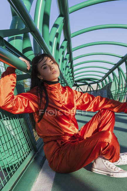 Mujer joven descansando apoyada en la barandilla del puente - foto de stock