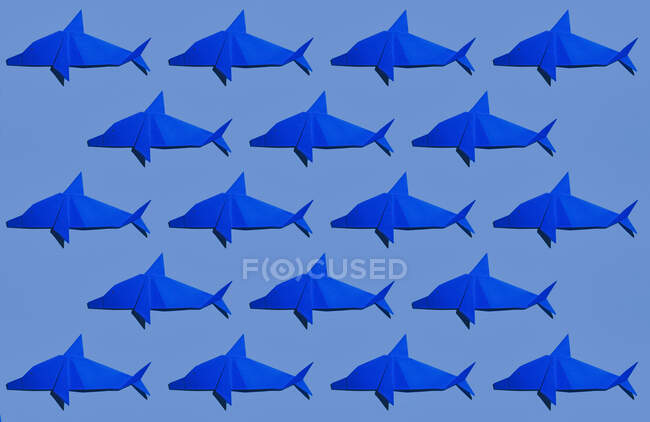 Origami di delfino blu disposti su sfondo colorato — Foto stock