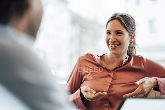 Безробітна жінка сміється, розмовляючи з колегою по кафе. — стокове фото