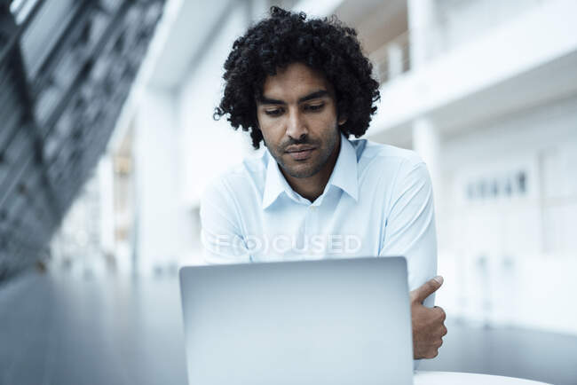 Giovane imprenditore maschio fiducioso utilizzando il computer portatile in ufficio — Foto stock