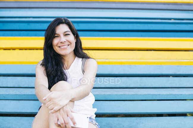 Bella donna seduta su più passi colorati — Foto stock