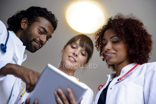 Professionisti sanitari di sesso maschile e femminile discutono su tablet digitale — Foto stock