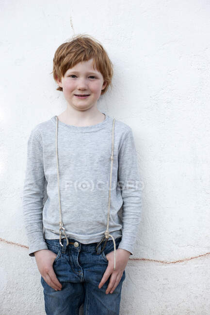 Cute boy standing in front of wall outdoors — Stock Photo