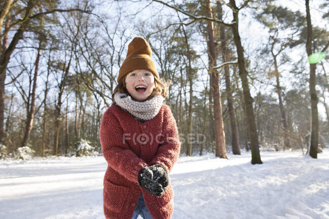 Curioso ragazzo in abiti caldi che gioca con la neve durante l'inverno — Foto stock