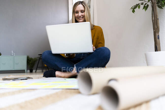 Sourire femme d'affaires créative en utilisant un ordinateur portable au bureau — Photo de stock