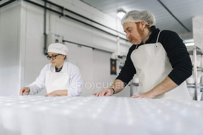 Köchinnen und Köche arbeiten in Käserei — Stockfoto