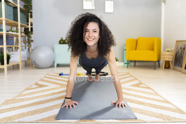 Lächelnde schöne Frau macht Liegestütze zu Hause — Stockfoto