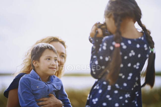 Chica fotografiando a madre y hermano - foto de stock